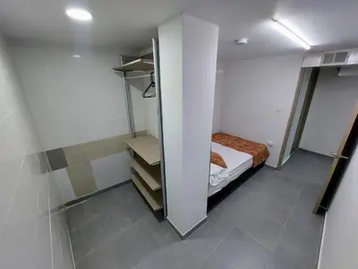 a small room with a bed and a closet at Tranquilo Apartamento Central Cerca a la Playa Puerto Colombia in Puerto Colombia