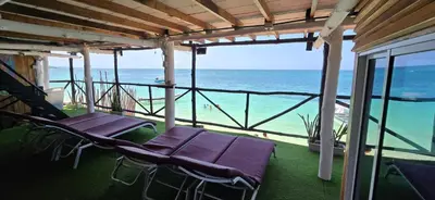 a porch with chairs and a view of the ocean at Ecohotelhector in Playa Blanca