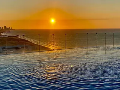 a swimming pool with the sun setting over the ocean at Morros in Cartagena de Indias