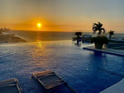 a swimming pool with a sunset in the background at Ctgna 10 personas 3 habitaciones Playa Américas Morros in Cartagena de Indias