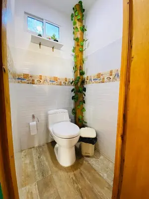 a bathroom with a toilet and a window at Freedom Beach Club in Baru