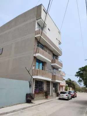 a building on a street with cars parked in front of it at Hermoso Apartamento Cerca a la Playa Puerto Colombia in Puerto Colombia
