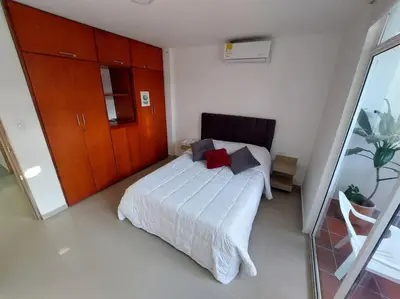 a bedroom with a white bed with red pillows at Hermoso Apartamento Cerca a la Playa Puerto Colombia in Puerto Colombia