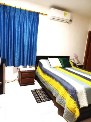 a bedroom with a bed and a blue curtain at Casa Bellavista Barranquilla in Barranquilla