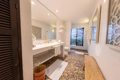 a white bathroom with a sink and a toilet at Hotel Agua Baru by Mustique in Baru