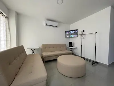 a living room with a couch and a stool at Apto 1er piso frente a la playa y con piscina in San Bernardo del Viento