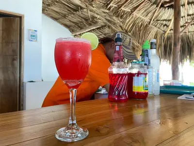 a drink in a glass sitting on top of a table at Apto 1er piso frente a la playa y con piscina in San Bernardo del Viento