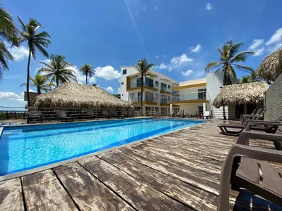 a swimming pool with chairs and a resort at Apto 1er piso frente a la playa y con piscina in San Bernardo del Viento