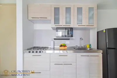 a kitchen with white cabinets and a stainless steel refrigerator at Coco Paraiso Baranquilla - Hermosos Apartamentos Cercanos Al Malecón Del Rio in Barranquilla