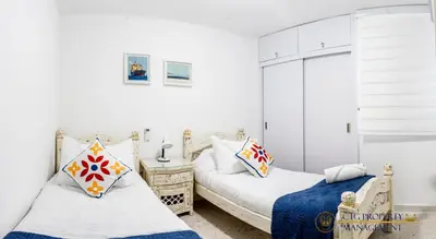 two beds in a room with white walls at Coco Paraiso Baranquilla - Hermosos Apartamentos Cercanos Al Malecón Del Rio in Barranquilla