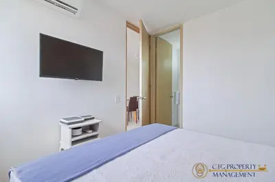 a bedroom with a bed and a flat screen tv at Coco Paraiso Baranquilla - Hermosos Apartamentos Cercanos Al Malecón Del Rio in Barranquilla