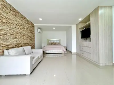 a bedroom with a bed and a white couch at HELENE HOUSE in Sincelejo
