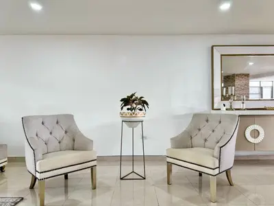 two chairs and a mirror in a living room at HELENE HOUSE in Sincelejo