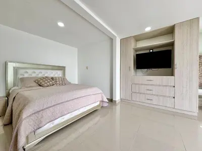 a bedroom with a bed and a flat screen tv at HELENE HOUSE in Sincelejo