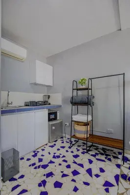 a kitchen with a blue and white floor and a chair at Mini departamento a una cuadra de la playa y de la bahia de Bocagrande in Cartagena de Indias