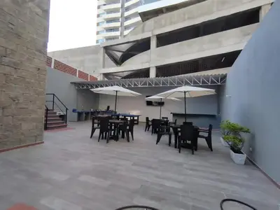 a patio with tables and chairs and umbrellas at Bm-2 room near the sea with air conditioning and WIFI in Cartagena de Indias