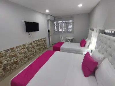 a bedroom with two beds and a flat screen tv at Bm-2 room near the sea with air conditioning and WIFI in Cartagena de Indias