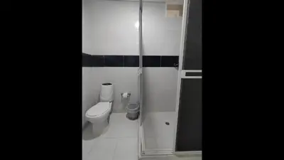 a bathroom with a toilet and a glass shower at Bm-2 room near the sea with air conditioning and WIFI in Cartagena de Indias