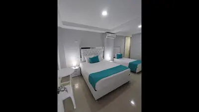 a bedroom with two beds and a table and a desk at Bm-17 Charming Cartagena Lodge with Shared Pool Terrace in Cartagena de Indias