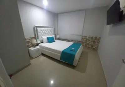 a small bedroom with a bed with a blue blanket at Bm-3 room near the sea with air conditioning and WIFI in Cartagena de Indias