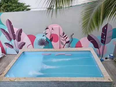 a swimming pool in front of a wall with a mural at Bm-5 room near the sea with air conditioning and WIFI in Cartagena de Indias