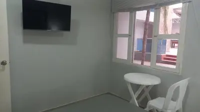 a room with a tv and a stool and a window at Bm-6 room near the sea with air conditioning and WIFI in Cartagena de Indias