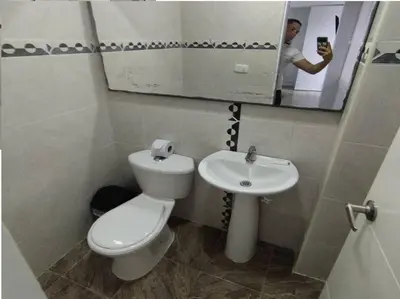 a man taking a picture of a bathroom with a toilet and sink at Bm-7 room near the sea with air conditioning and WIFI in Cartagena de Indias