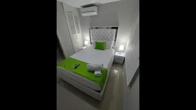 a small bed in a small room with a green blanket at Bm-14G Charming Cartagena Lodge with Shared Pool and Private Terrace in Cartagena de Indias