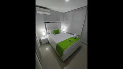 a bedroom with a green bed and a window at Bm-14G Charming Cartagena Lodge with Shared Pool and Private Terrace in Cartagena de Indias