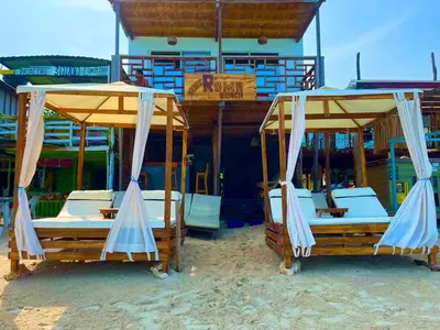 two beds with umbrellas in front of a resort at Roma beach in Cartagena de Indias