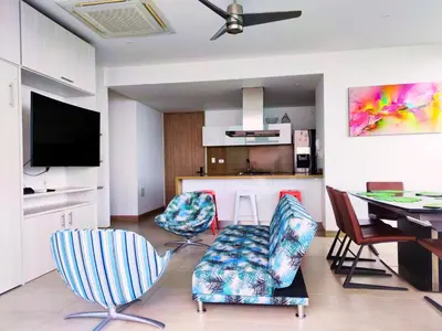 a living room with chairs and a table and a kitchen at Playa Dormida 2. Hermoso apartamento frente al mar in Santa Marta