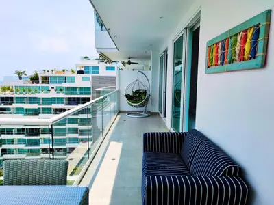 a living room with a couch on a balcony at Playa Dormida 2. Hermoso apartamento frente al mar in Santa Marta